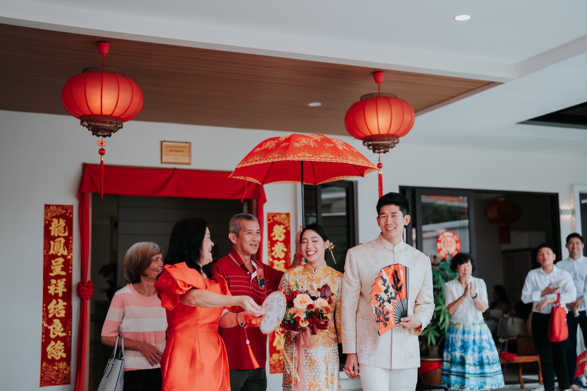 Bride and groom under a red parasol at a Chinese wedding in Kuala Lumpur