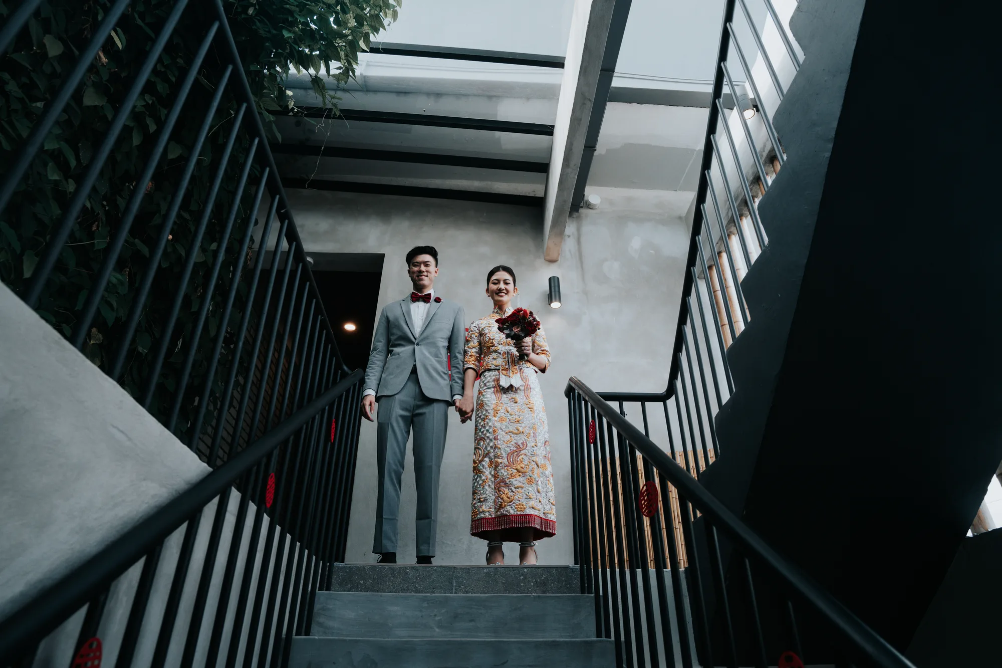 A bride and groom hold hands as they go down a staircase