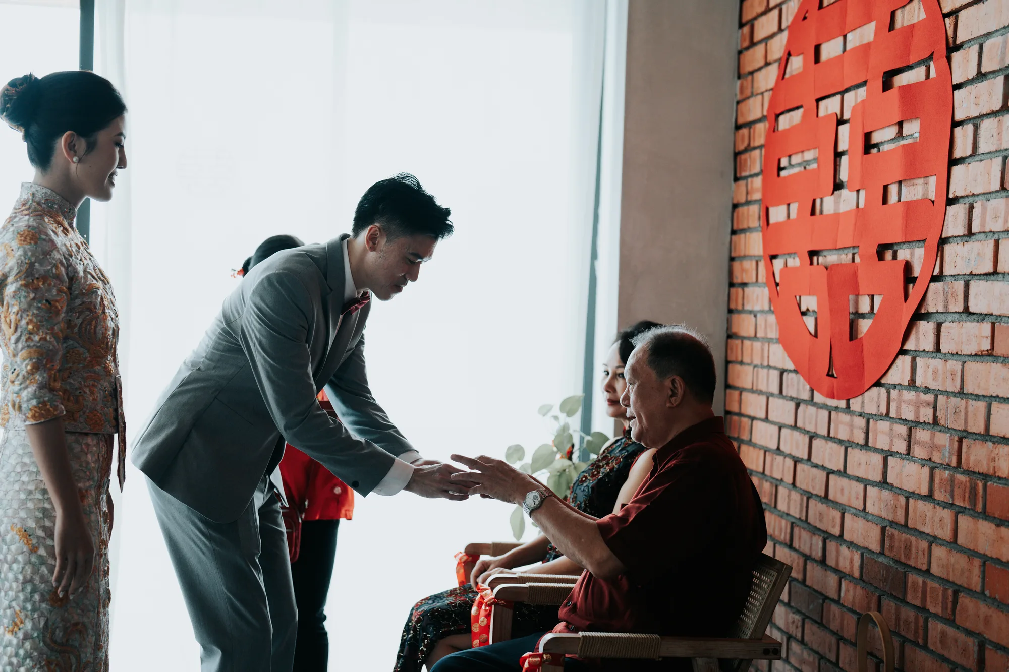 A groom bows to an elder during the tea ceremony