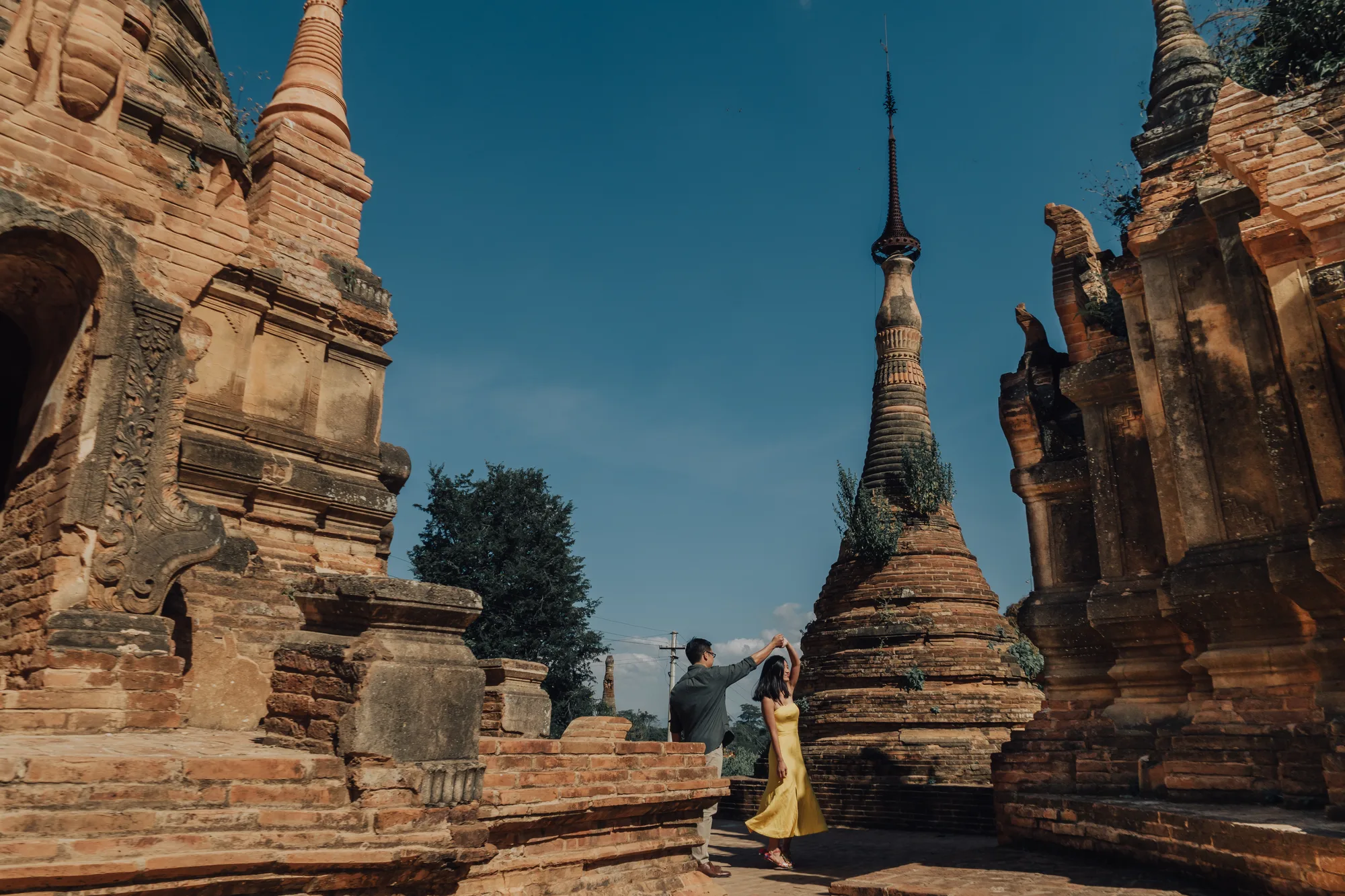 A couple dances amidst ancient temples under a clear blue sky