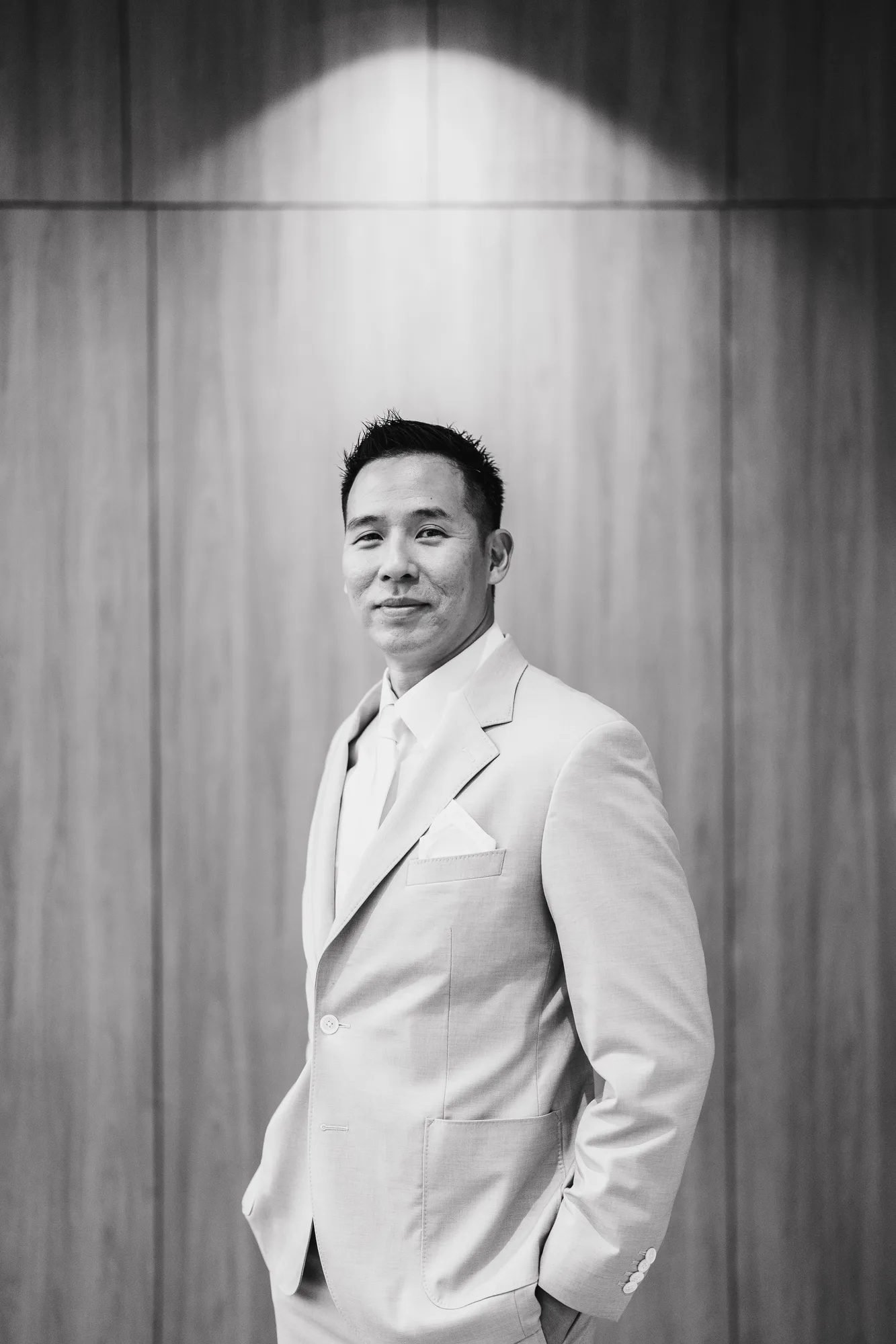 A groom in a cream suit on his wedding morning